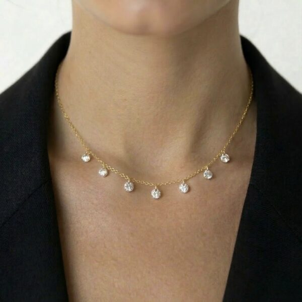 שרשרת Gleam עשויה כסף 925 בציפוי זהב 14 קראט עם שבעה זרקונים קדוחים ואורך מתכוונן על הדוגמנית