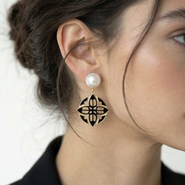 עגיל Éme עשוי כסף 925 בציפוי זהב 14 קארט עם פנינה ממים מתוקים ואמייל שחור על הדוגמנית