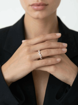 תקריב של טבעת זירקונים רוז גולד בעיצוב גלים א-סימטרי נוצץ - TALIA