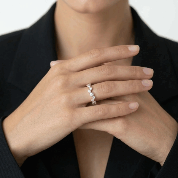 תקריב של טבעת זירקונים רוז גולד בעיצוב גלים א-סימטרי נוצץ - TALIA